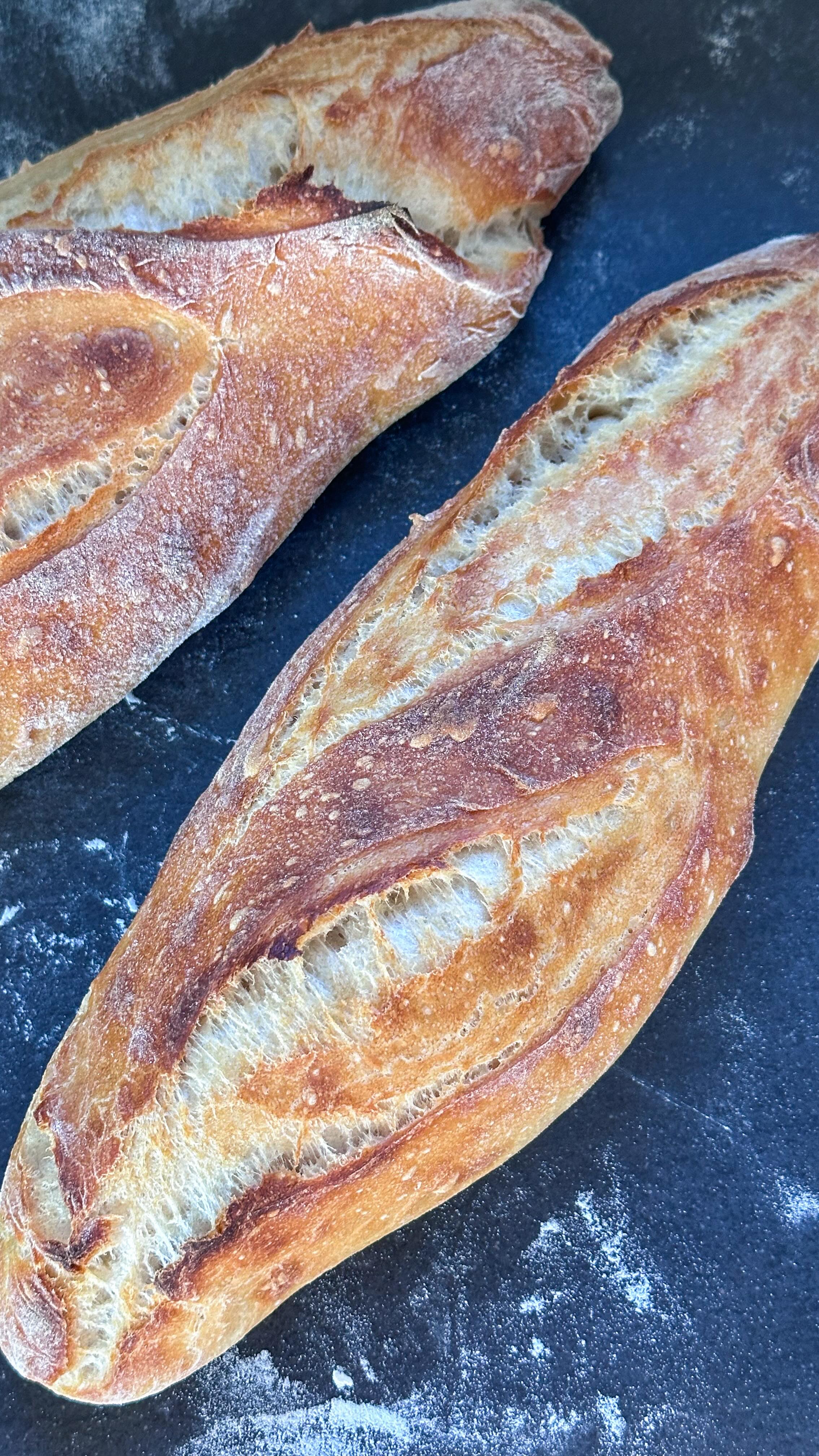 Ihr werdet ab sofort keine Baguettes mehr kaufen wollen 🥖🤞🏻! 

200g Weizenmehl 550, 200g Manitobamehl (oder nochmal Weizenmehl 550) und 280ml Wasser kurz miteinander vermengen und für 30 Minuten stehen lassen. Dann 11g Salz und 100g Weizensauerteig dazugeben und für 5 Minuten kneten. 

Bei Zimmertemperatur für 2h ruhen lassen und nach jeweils 1h dehnen und falten. Dann über Nacht im Kühlschrank ruhen lassen. 

Am nächsten Tag den Teig in zwei Teile teilen und zu Baguettes formen. Jeweils zwei Mal längs einschneiden und dann bei 230 Grad Ober- Unterhitze für ca. 20-25 Minuten backen. 

#sauerteigbrot #gesundbacken #gesundeernährung #darmgesundheit #familienrezepte